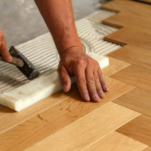 A worker installing parquet flooring